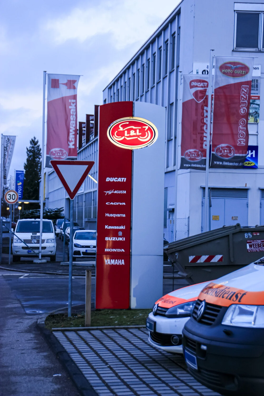 Firmenschild mit Logo an einer Gebäudefassade